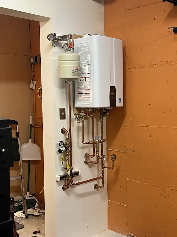 Plumbing technician inspecting water heater connections in Torrance